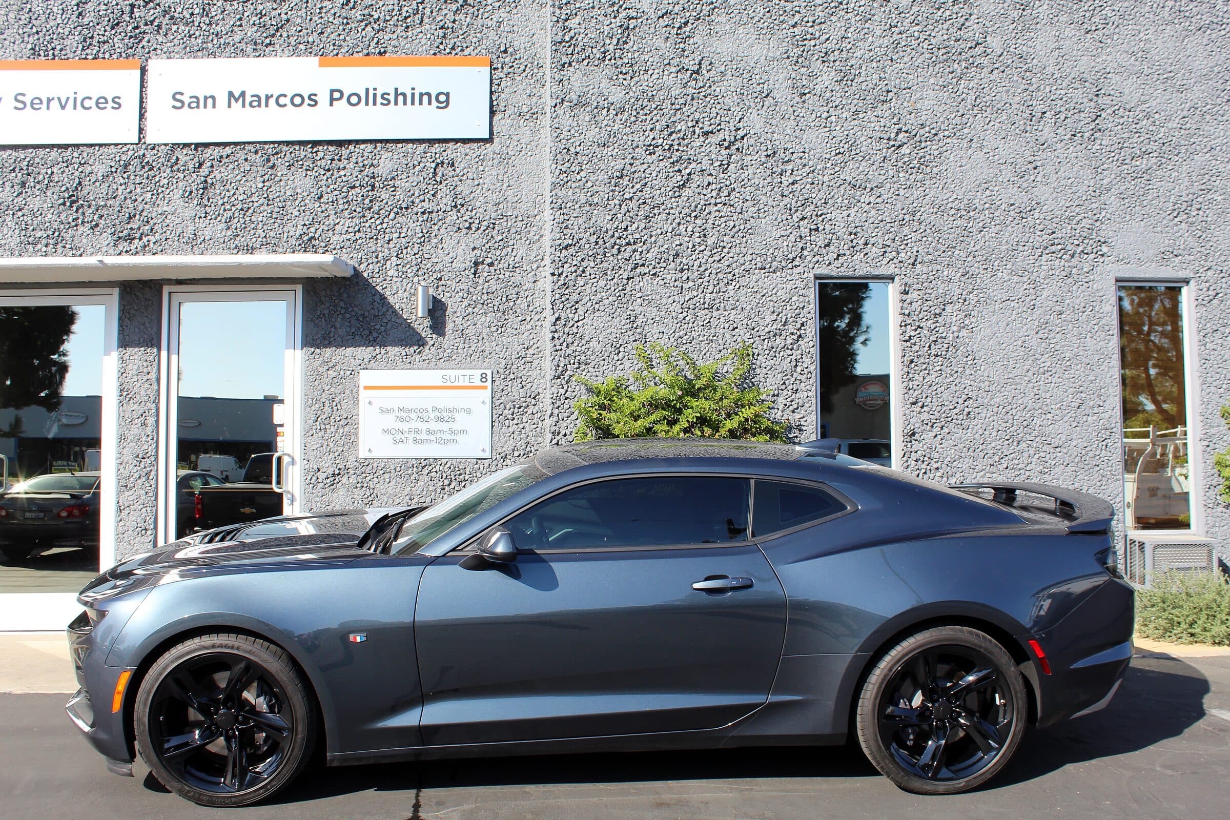 The San Marcos Powder Coating shop front with a customer car parked outside
